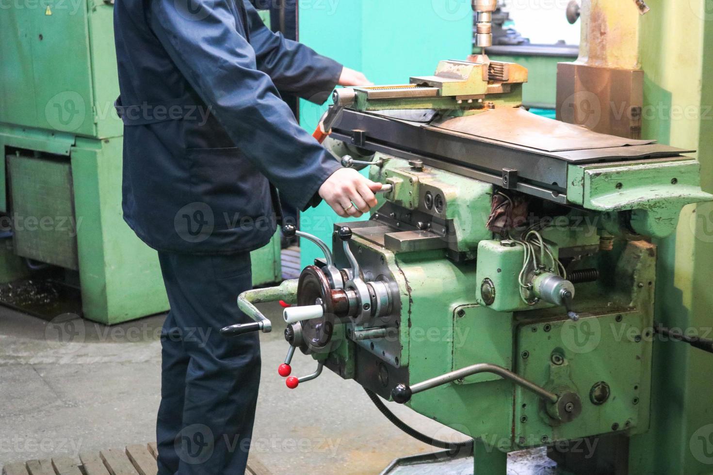 um trabalhador do sexo masculino trabalha em um torno de serralheiro de ferro de metal maior, equipamento para reparos, trabalho em metal em uma oficina em uma planta metalúrgica em uma produção de reparo foto