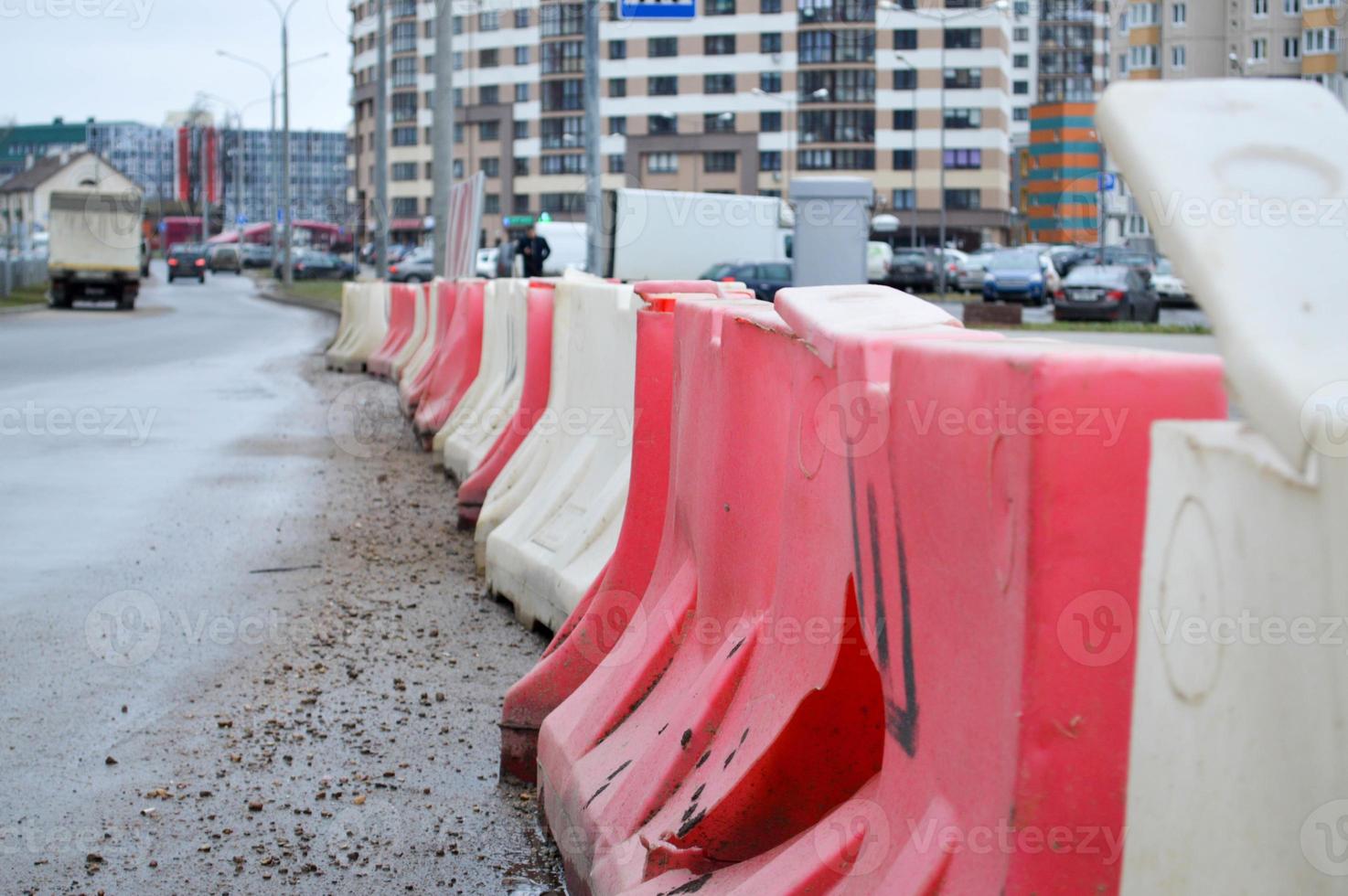 grandes blocos de plástico vermelho e branco cheios de água para segurança nas estradas durante os reparos nas estradas foto
