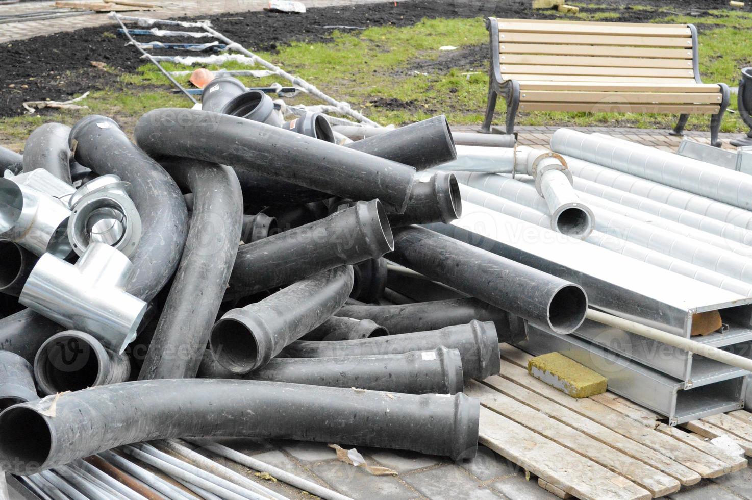 grandes tubos de esgoto de plástico preto para a construção de tubos de água ou esgotos em um canteiro de obras durante o reparo foto