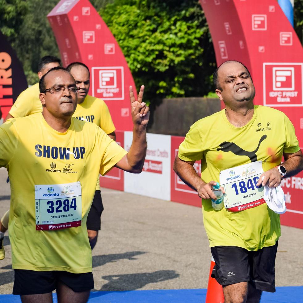 nova delhi, índia - 16 de outubro de 2022 - vedanta delhi meia maratona após covid em que os participantes da maratona prestes a cruzar a linha de chegada, meia maratona de delhi 2022 foto