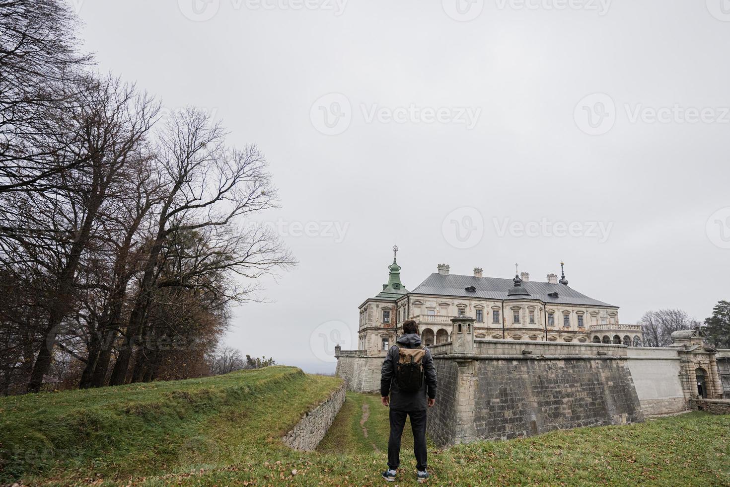 costas do homem turista com mochila visitam o castelo pidhirtsi, região de lviv, ucrânia. foto