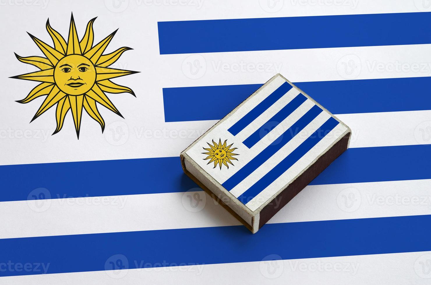 a bandeira do uruguai é retratada em uma caixa de fósforos que fica em uma bandeira grande foto