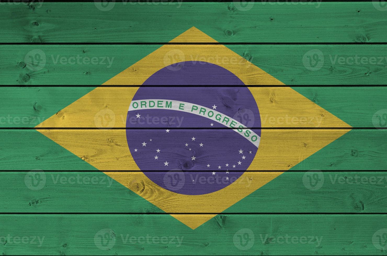 bandeira do brasil retratada em cores de tinta brilhante na parede de madeira velha. banner texturizado em fundo áspero foto