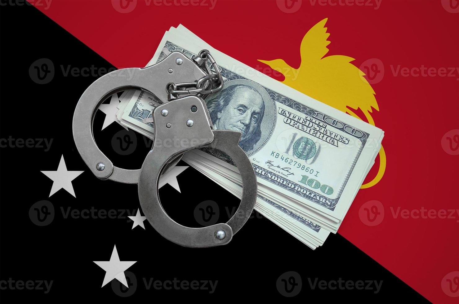 bandeira de papua nova guiné com algemas e um maço de dólares. corrupção monetária no país. crimes financeiros foto