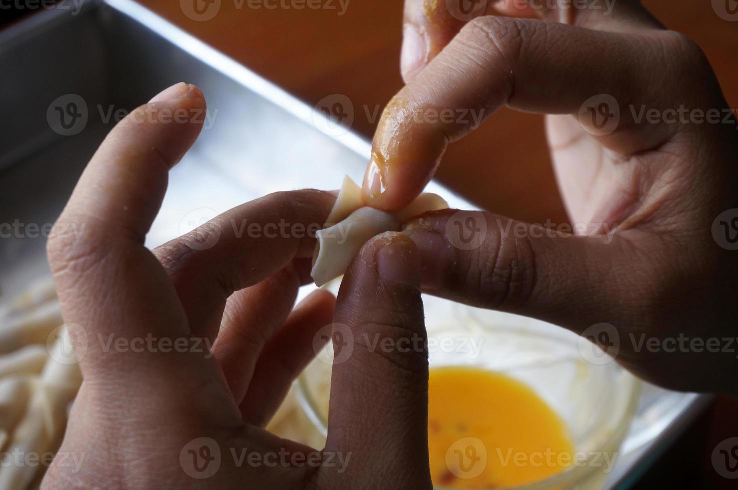 o processo de fazer ou cozinhar um kacang sembunyi, lanche popular da indonésia. feijão envolto em uma pele de massa de farinha. frito em óleo e açúcar líquido. foto