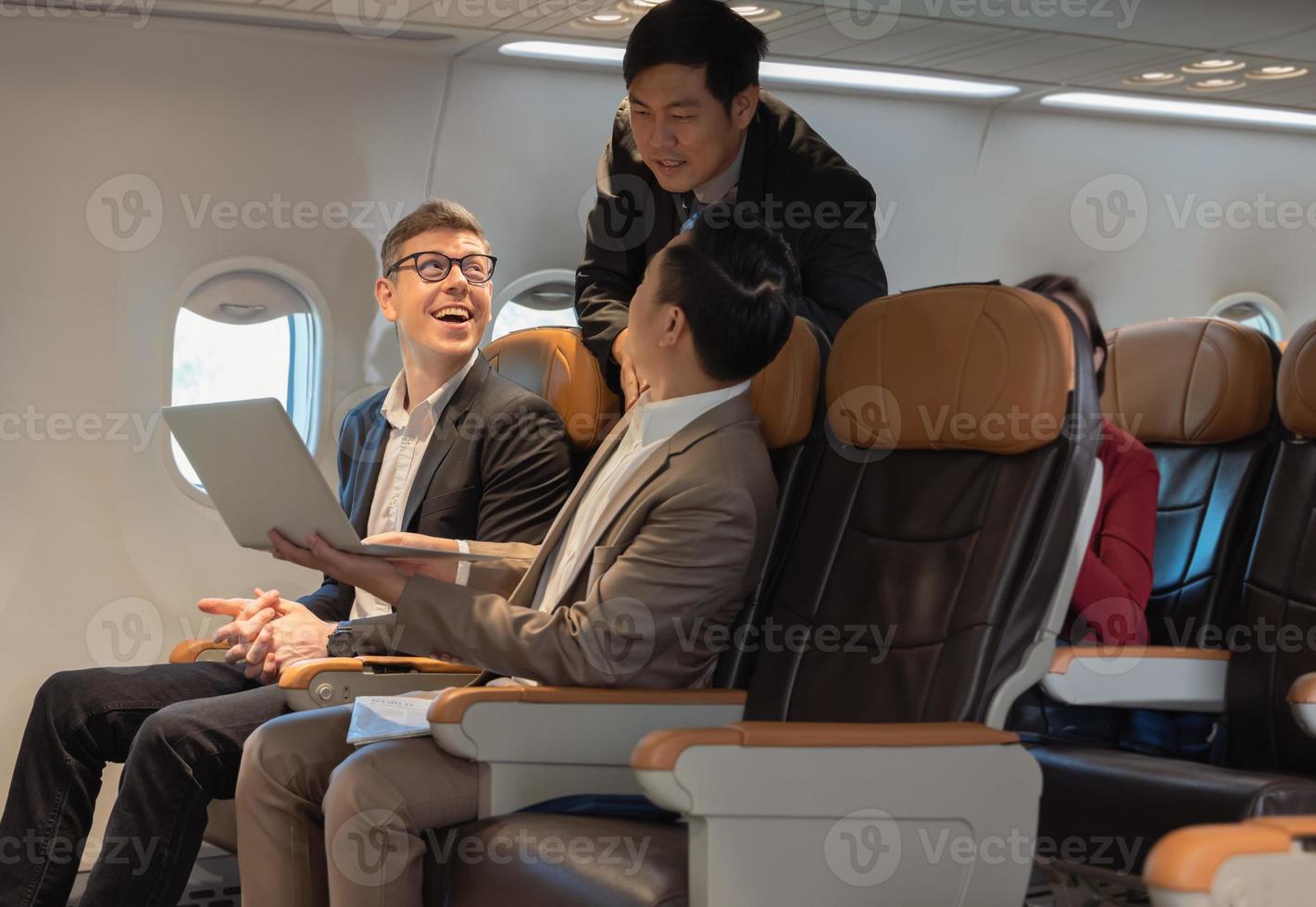 empresários de felicidade trabalhando juntos no laptop durante o voo foto
