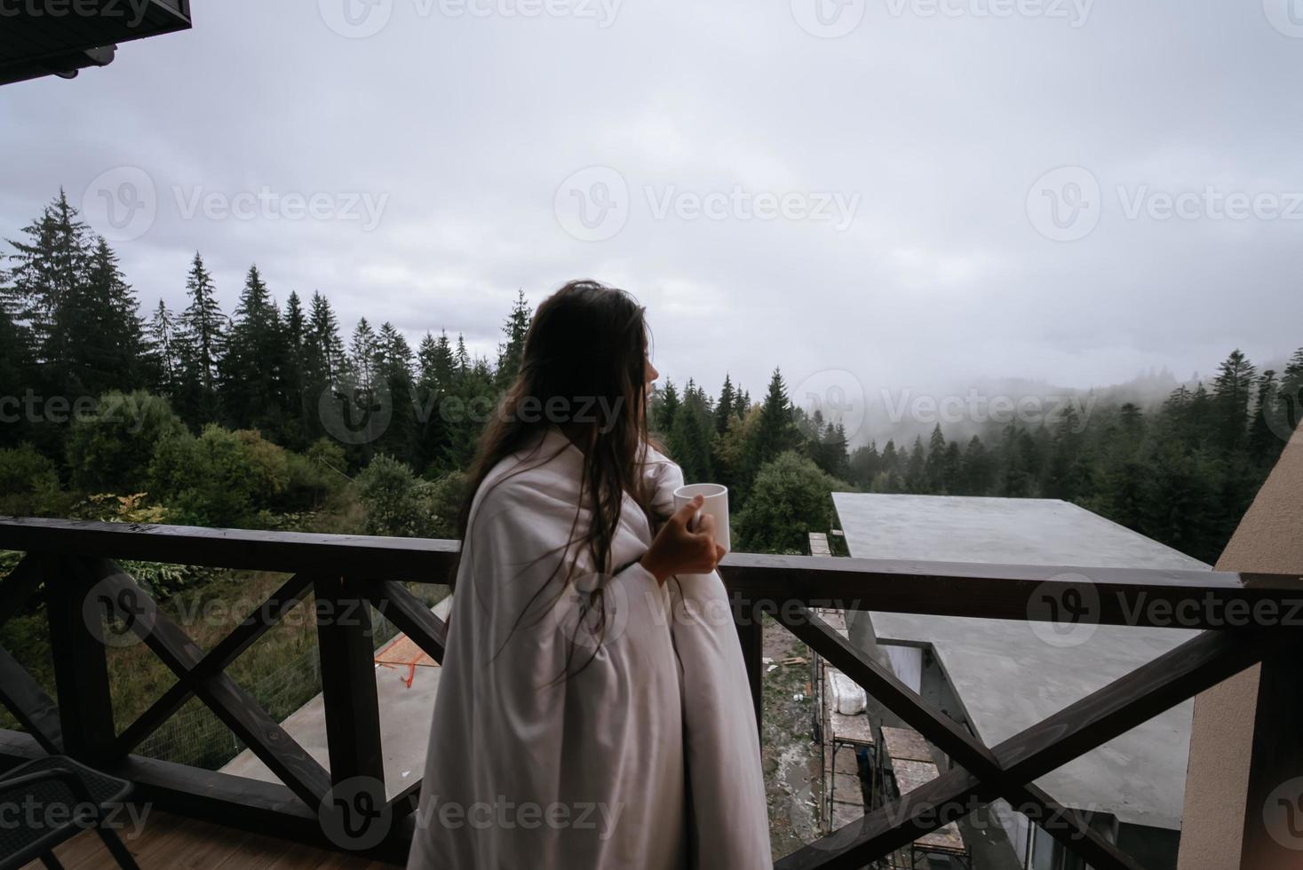 mulher bebendo chá na aconchegante varanda de uma casa de campo. foto