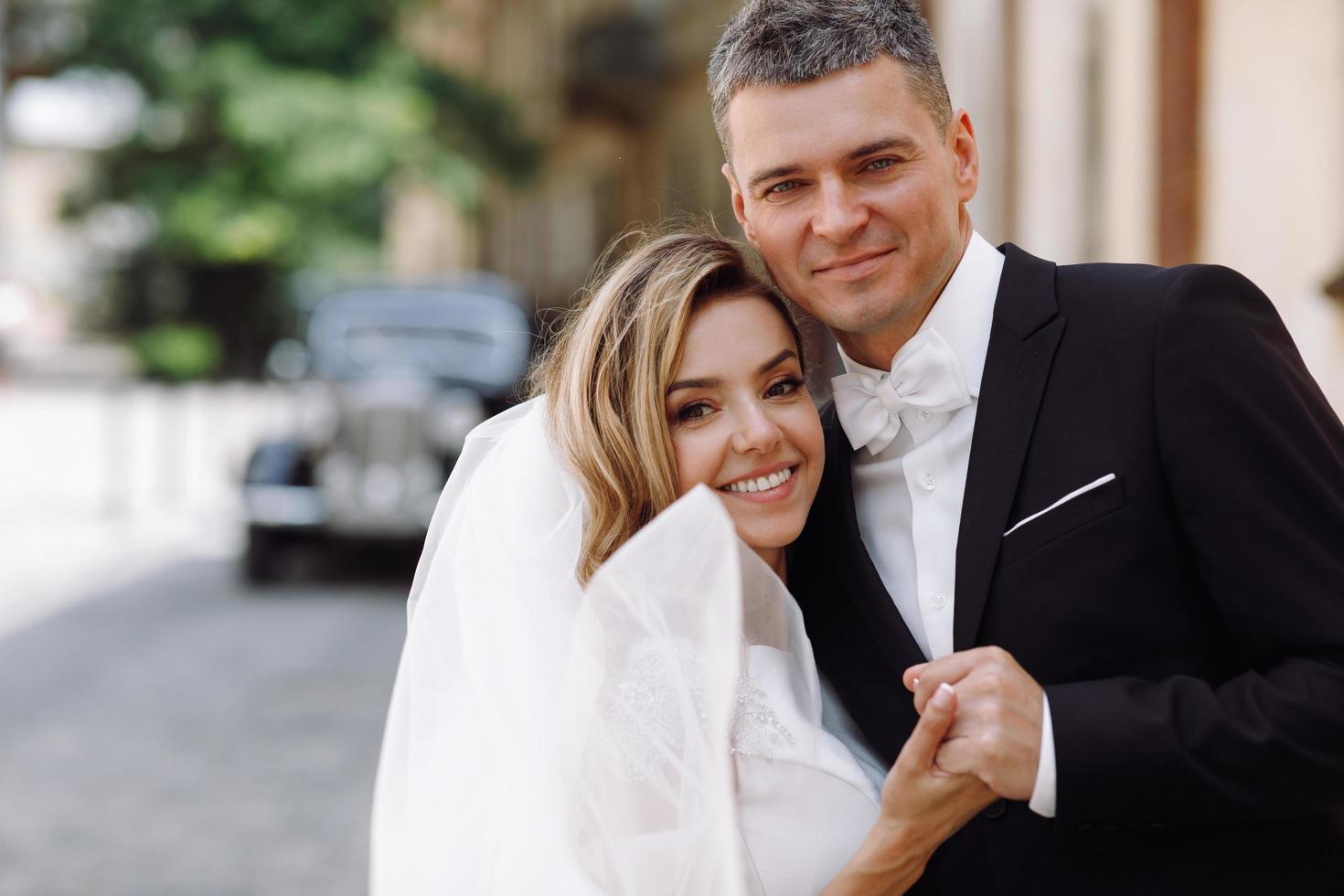 noiva e noivo elegantes na velha rua europeia foto