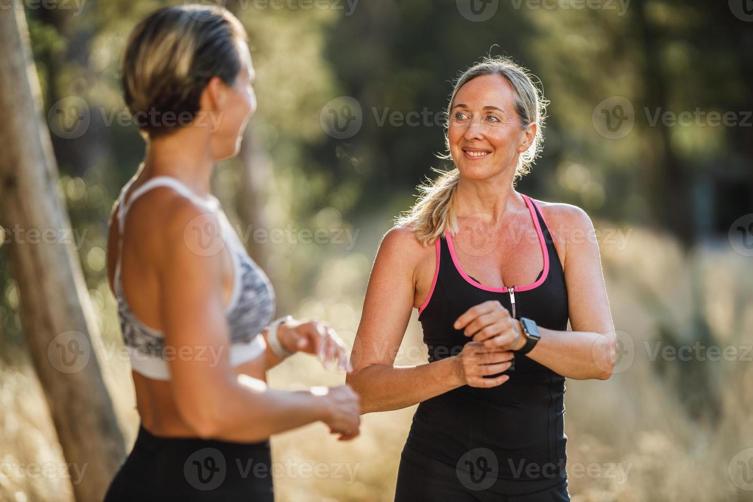 duas mulheres corredores fazendo uma pausa enquanto correm no parque em um dia de verão foto