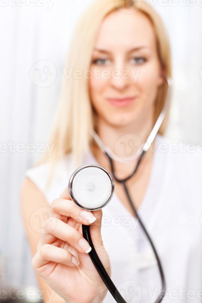 médico feminino segurando o estetoscópio foto