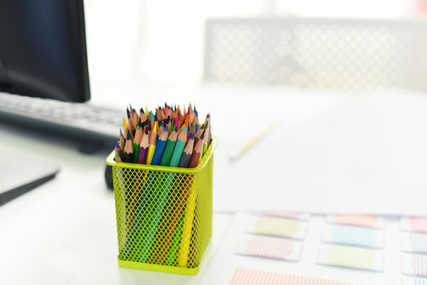 escrivaninha no escritório com computador e lápis de cor ou giz de cera colorido para mesa de escrivaninha local de trabalho fundo de escritório de negócios foto