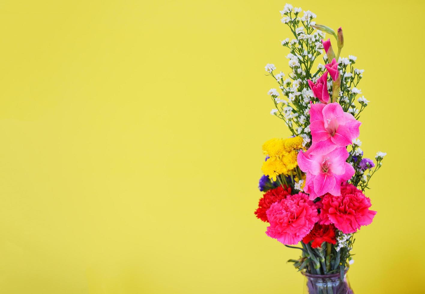 planta colorida de bando de flores frescas de primavera com gladíolo de flores de cravo e vários lindos em fundo amarelo foto