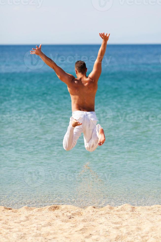 homem feliz pulando na água foto