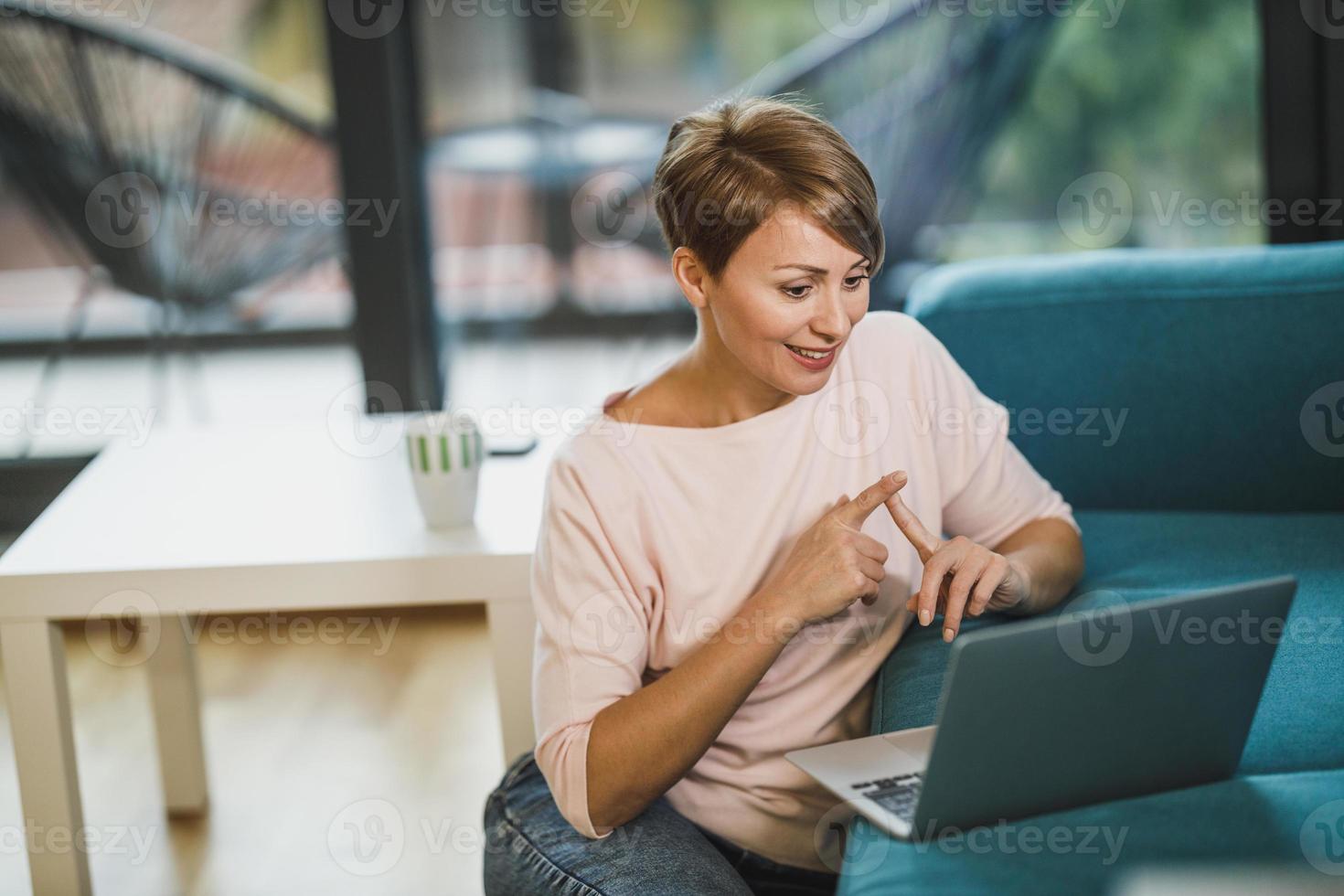 mulher participando de uma reunião online no laptop enquanto trabalhava em casa foto