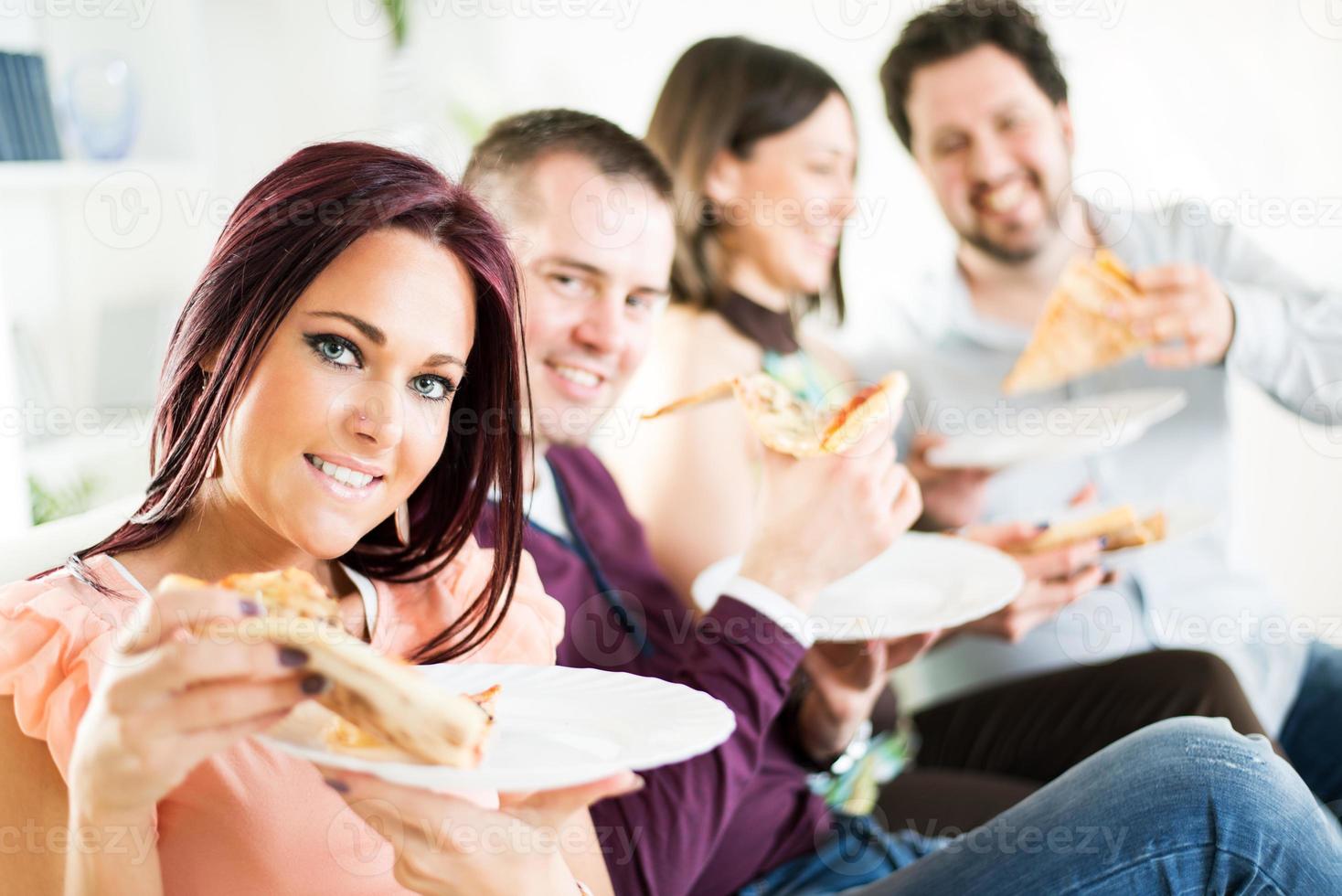 amigos alegres comendo pizza foto