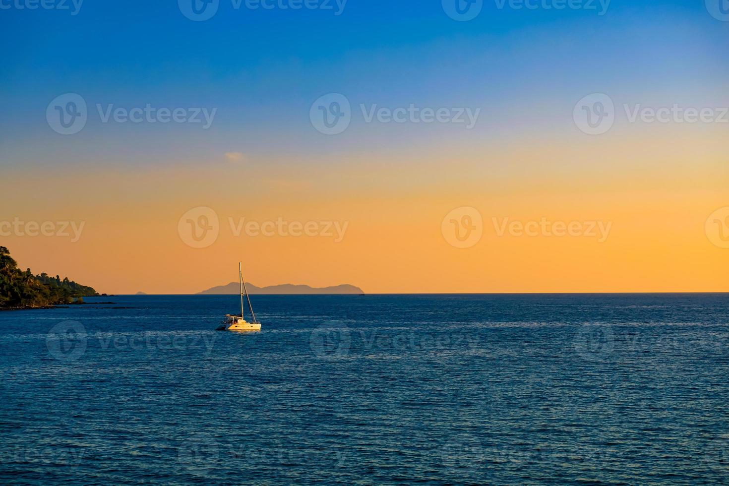 superfície do mar e horizonte com iate na bela vista do mar por do sol no fundo foto