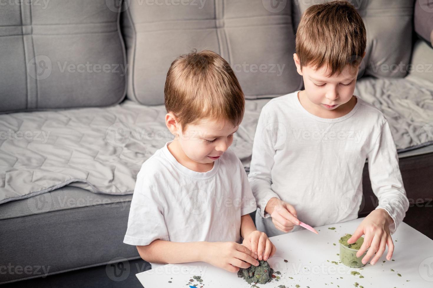 as crianças brincam com areia cinética em casa. desenvolvimento de habilidades motoras finas. areia antiestresse para crianças. jogos que acalmam o sistema nervoso. areia colorida para jogos foto