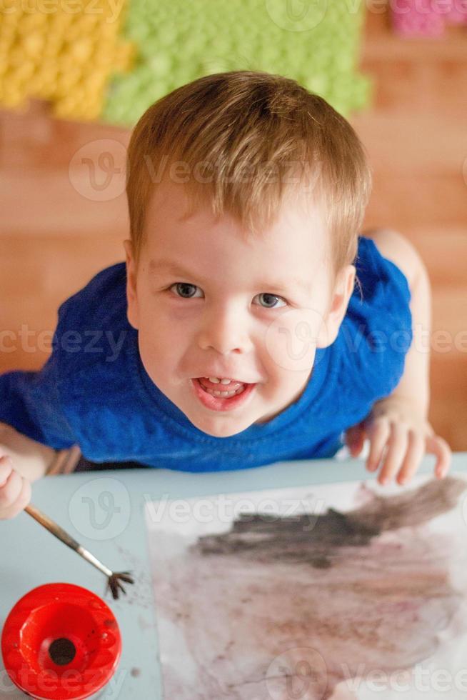 retrato de um menino de cabelos loiros, pintando um quadro. parto precoce. criatividade desde a infância. foto