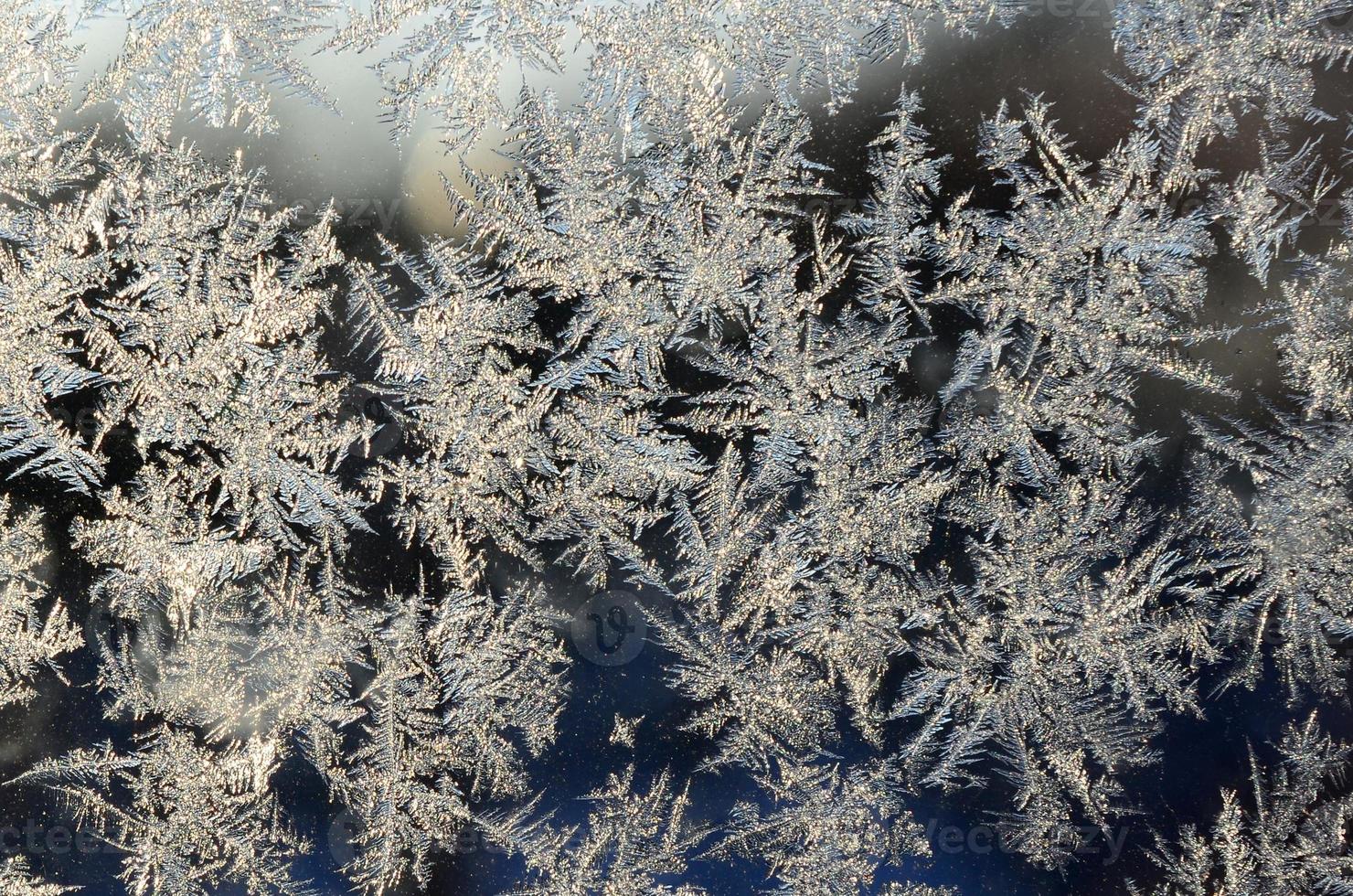 macro de geada de flocos de neve no painel de vidro da janela foto