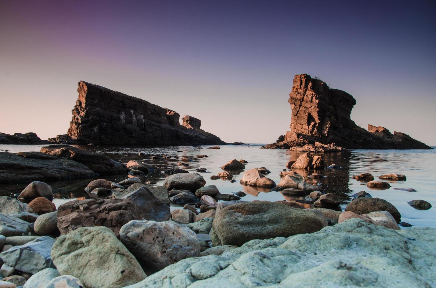 pedras cinzentas perto da massa de água foto