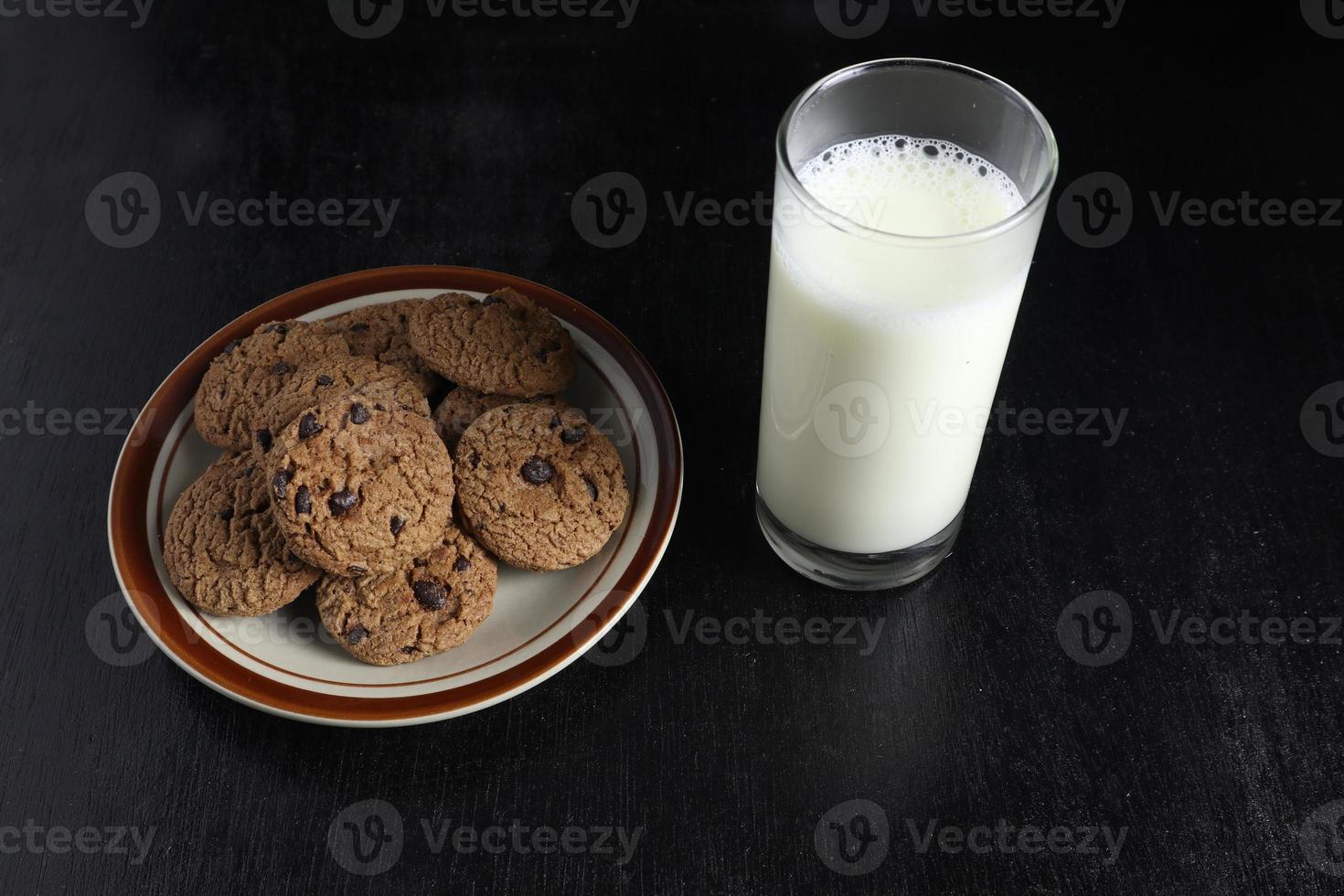 biscoitos e leite em fundo preto. espaço para texto foto