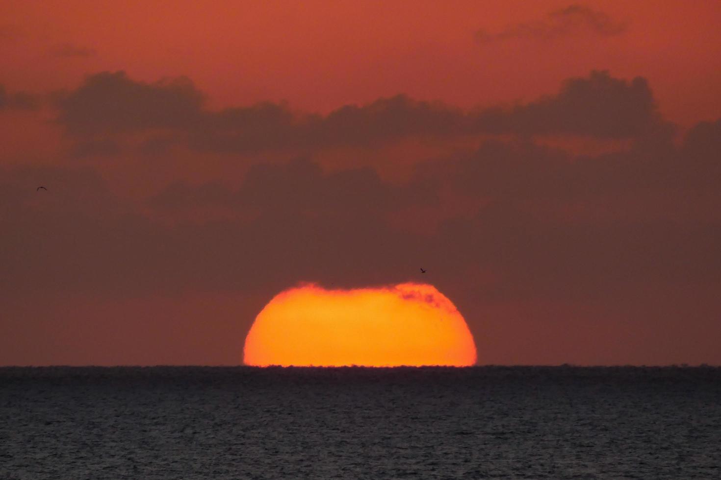 disco solar subindo no horizonte do mar, nascer do sol, amanhecer foto