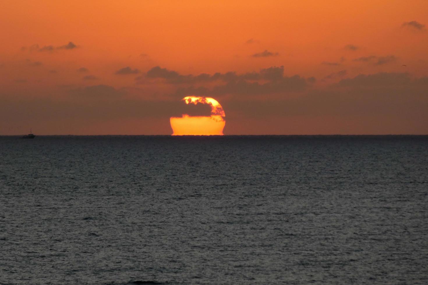 disco solar subindo no horizonte do mar, nascer do sol, amanhecer foto