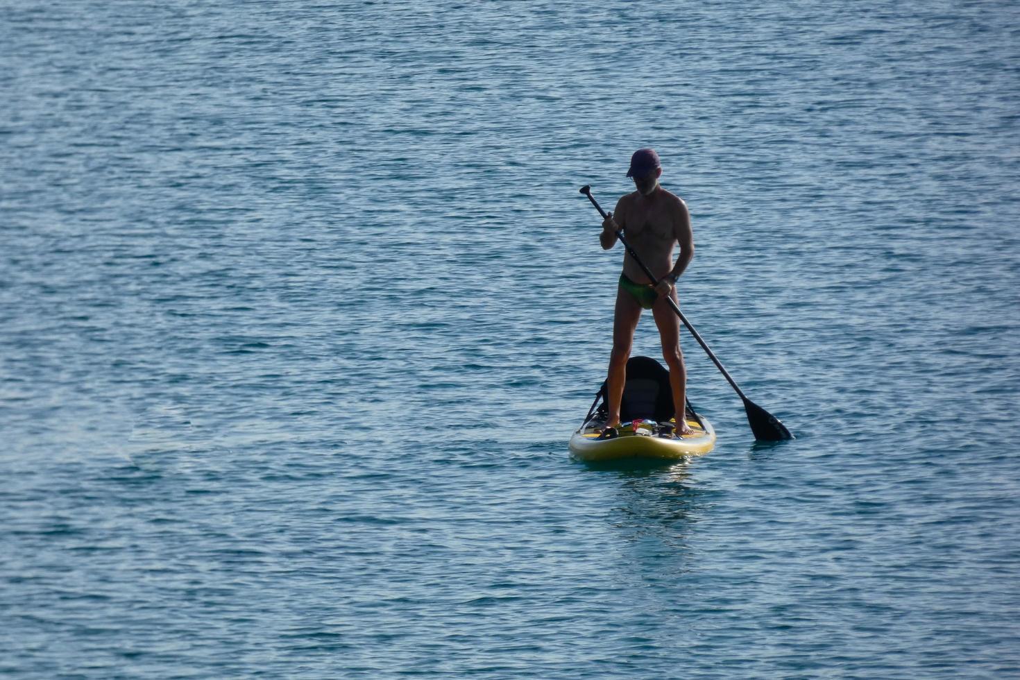 nadador de férias paddle surf no mar mediterrâneo foto