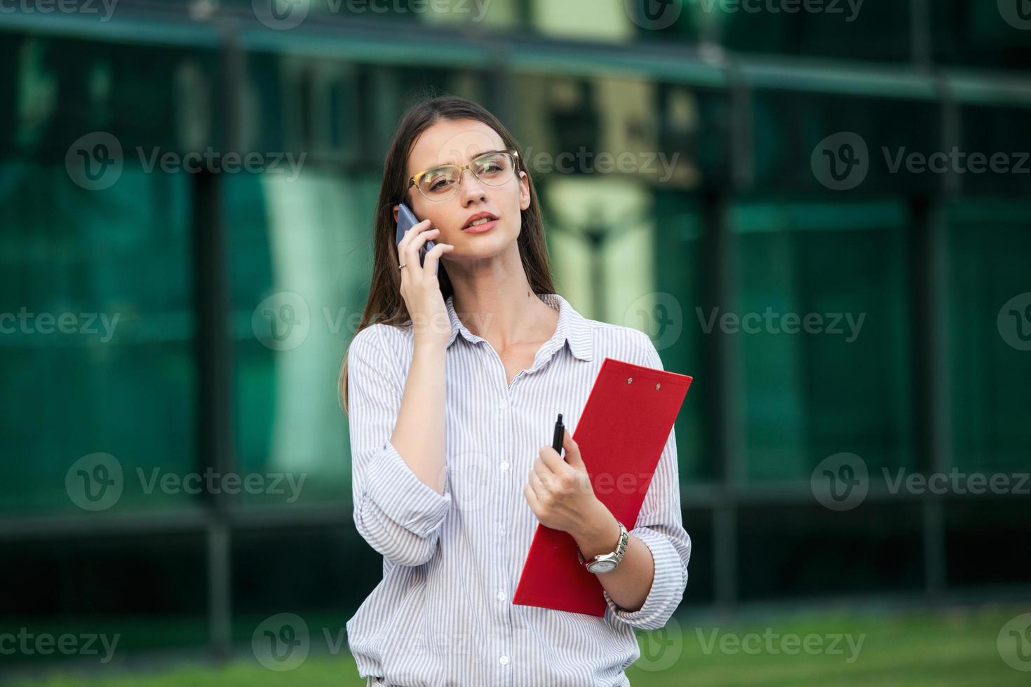 empresária com roupa formal, tendo problemas com contratos, falando ao telefone e segurando a área de transferência. empresária zangada com falha na papelada no local de trabalho, executivos tendo conflito foto