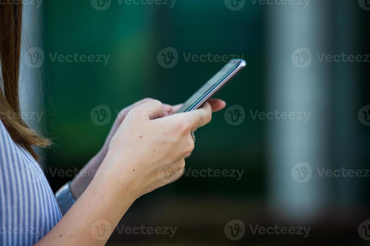 close-up das mãos das mulheres segurando o telefone celular com tela de espaço de cópia em branco para sua mensagem de texto de publicidade ou conteúdo promocional foto