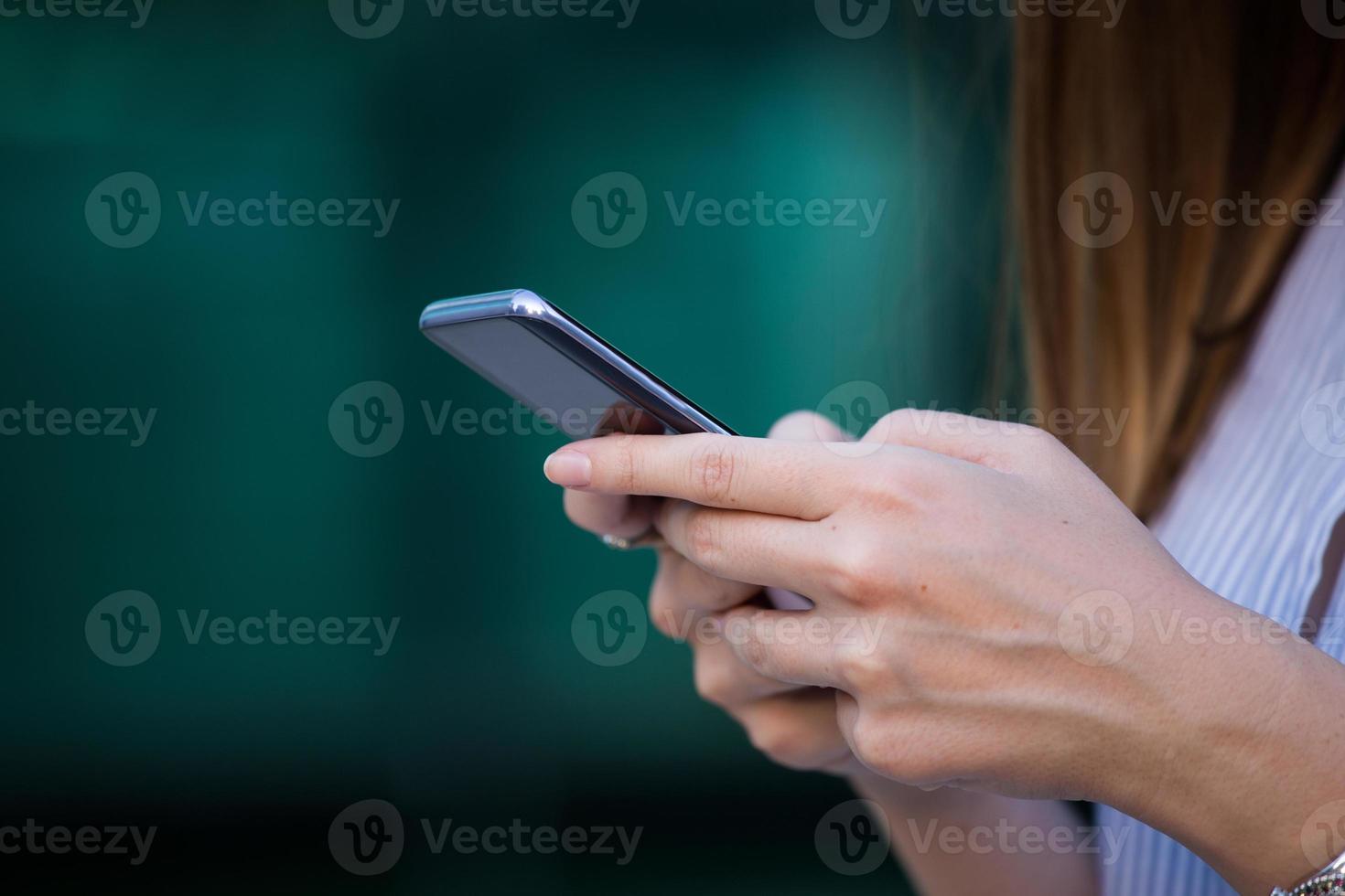 close-up das mãos das mulheres segurando o telefone celular com tela de espaço de cópia em branco para sua mensagem de texto de publicidade ou conteúdo promocional foto