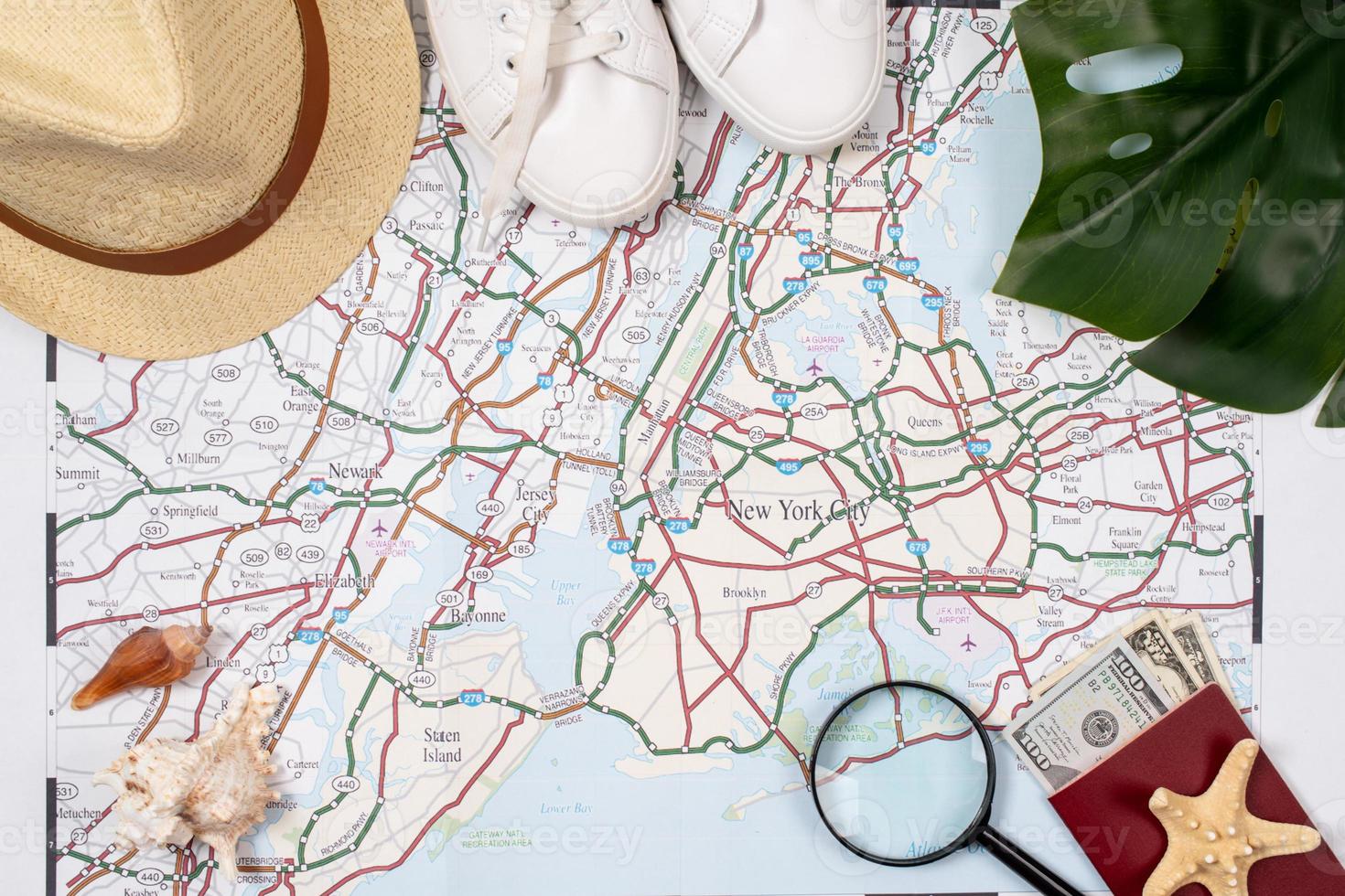 acessórios de viajante com mapa, dispositivos e roupas em fundo branco foto