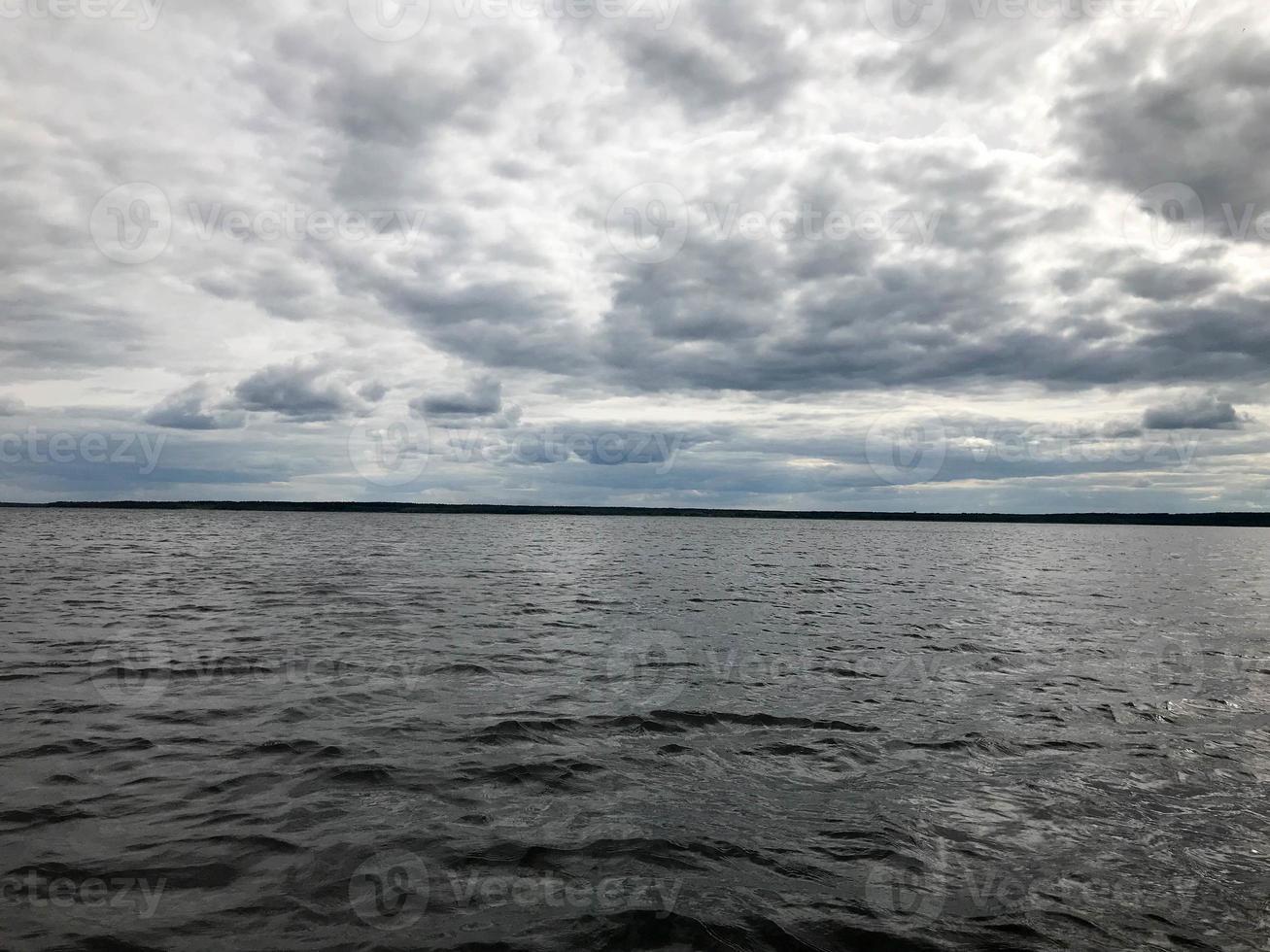 paisagem da natureza da linha do horizonte com vista para a costa, água com ondas do meio do lago no tempo frio e nublado foto