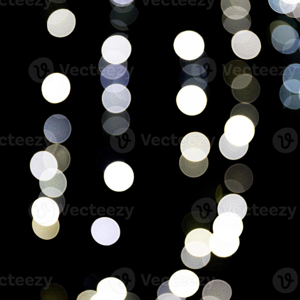 bokeh de luz abstrato como fundo desfocado e desfocado muitas luzes redondas em fundo preto foto