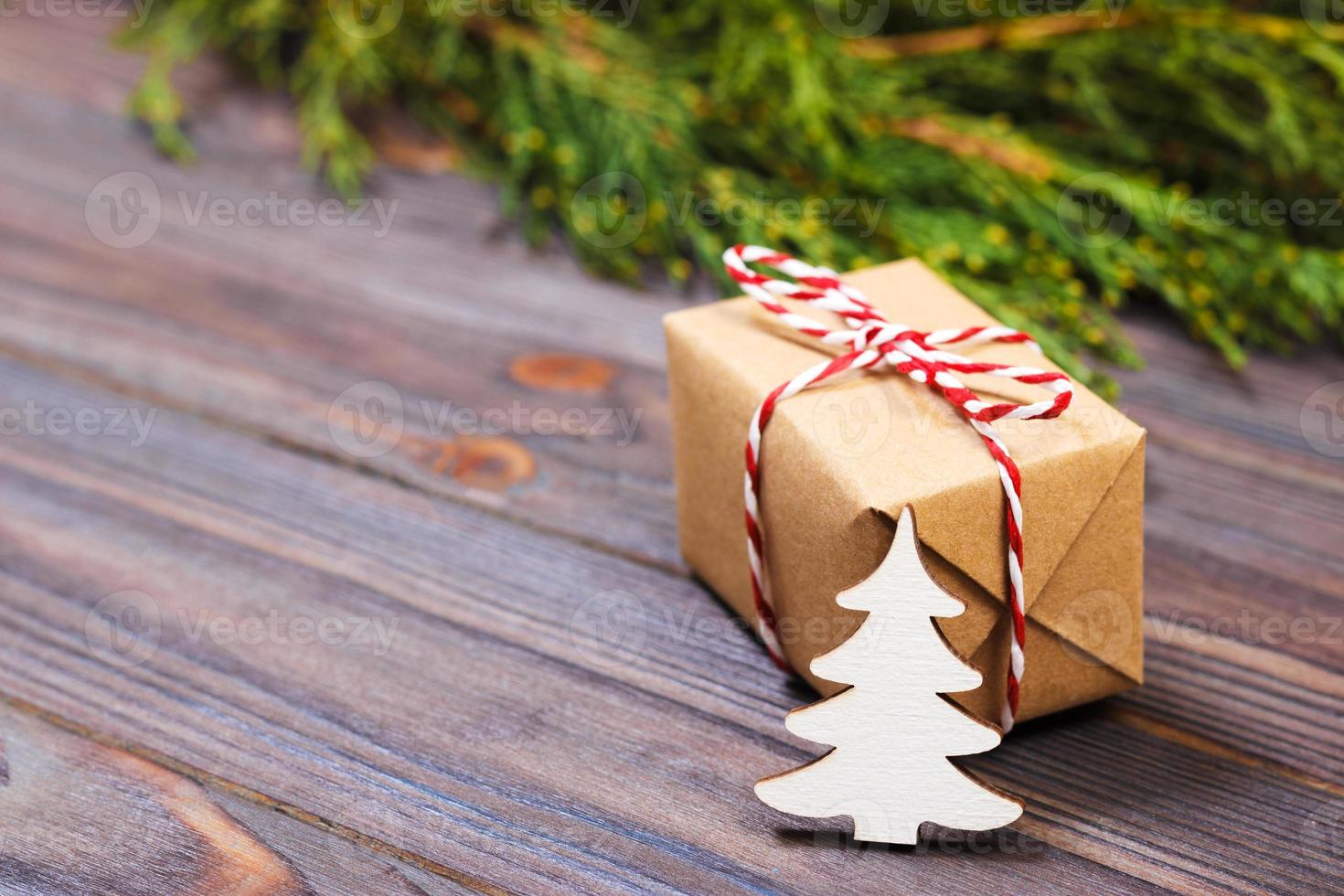 pequena árvore de natal de madeira branca decorativa e presente com conceito de ano novo de fita vermelha, presente de papel kraft foto