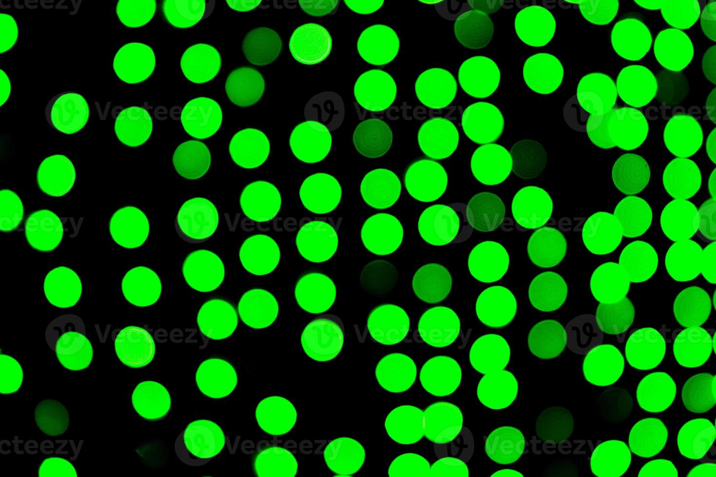 bokeh verde abstrato sem foco sobre fundo preto. desfocado e desfocado muitas luzes redondas foto