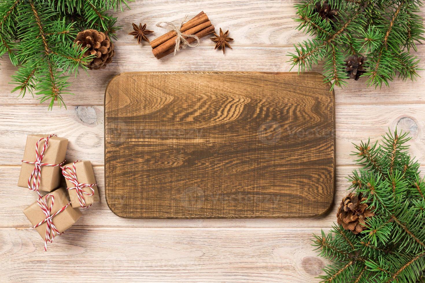 tábua de corte de madeira no fundo da mesa com decoração de natal, tábua redonda. conceito de ano novo foto