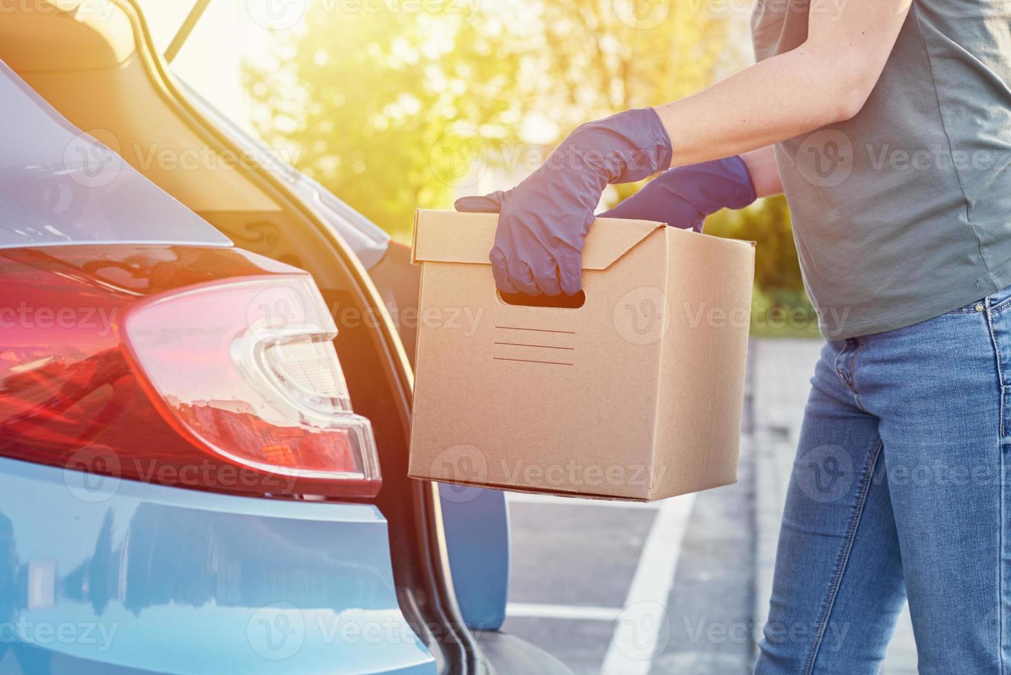 conceito de serviço de entrega. mulher carregando caixa no carro foto