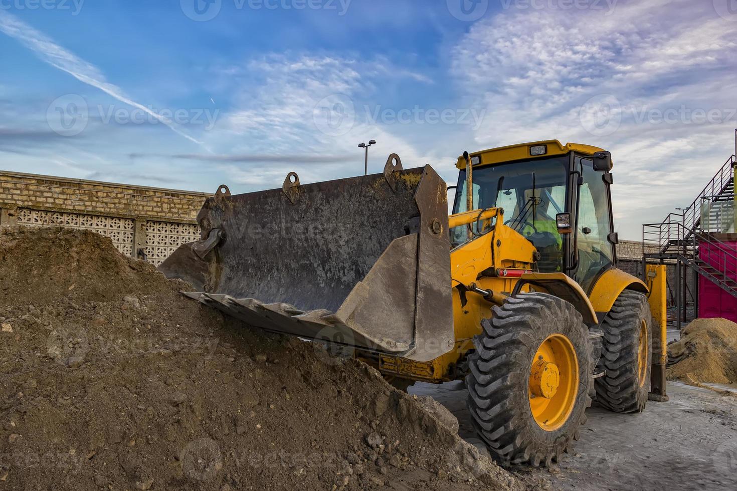 visão do dia da escavadeira amarela com pá no canteiro de obras foto