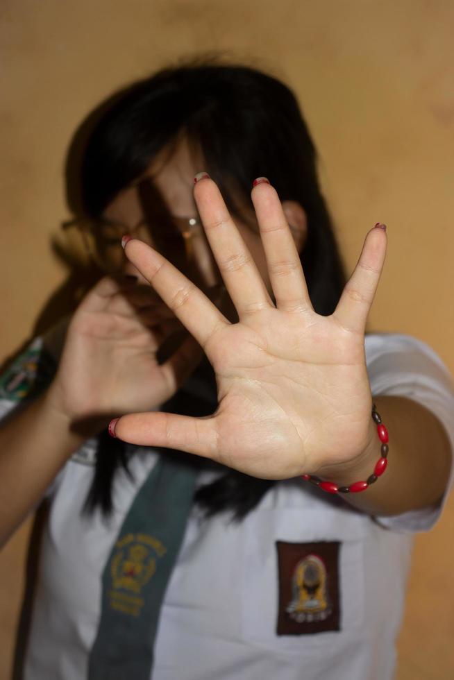 nas mãos de uma mulher em um conceito de uniforme do ensino médio de parar o bullying na escola. foto