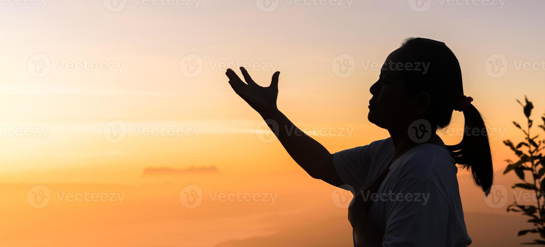 a fé da oração espiritual do conceito cristão entrega a luz do sol com um belo nascer do sol ou fundo do pôr do sol desfocado. cristãos que acreditam, fé na oração matinal de Deus. foto