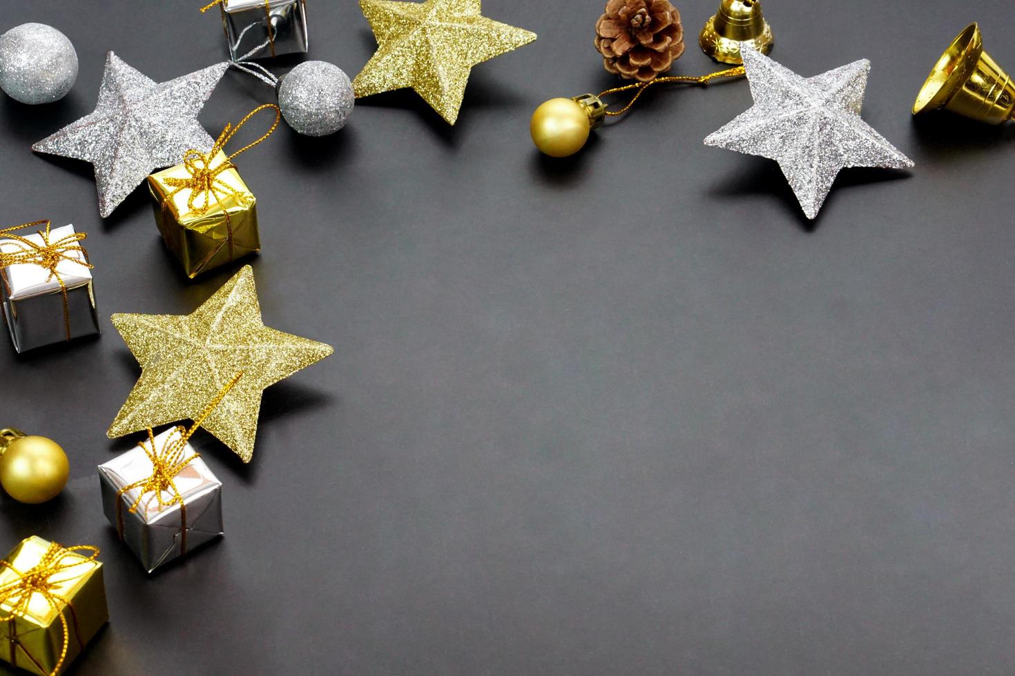 estrelas coloridas ouro-prata, caixa de presente e bolas decorativas em fundo preto com espaço de cópia. foto