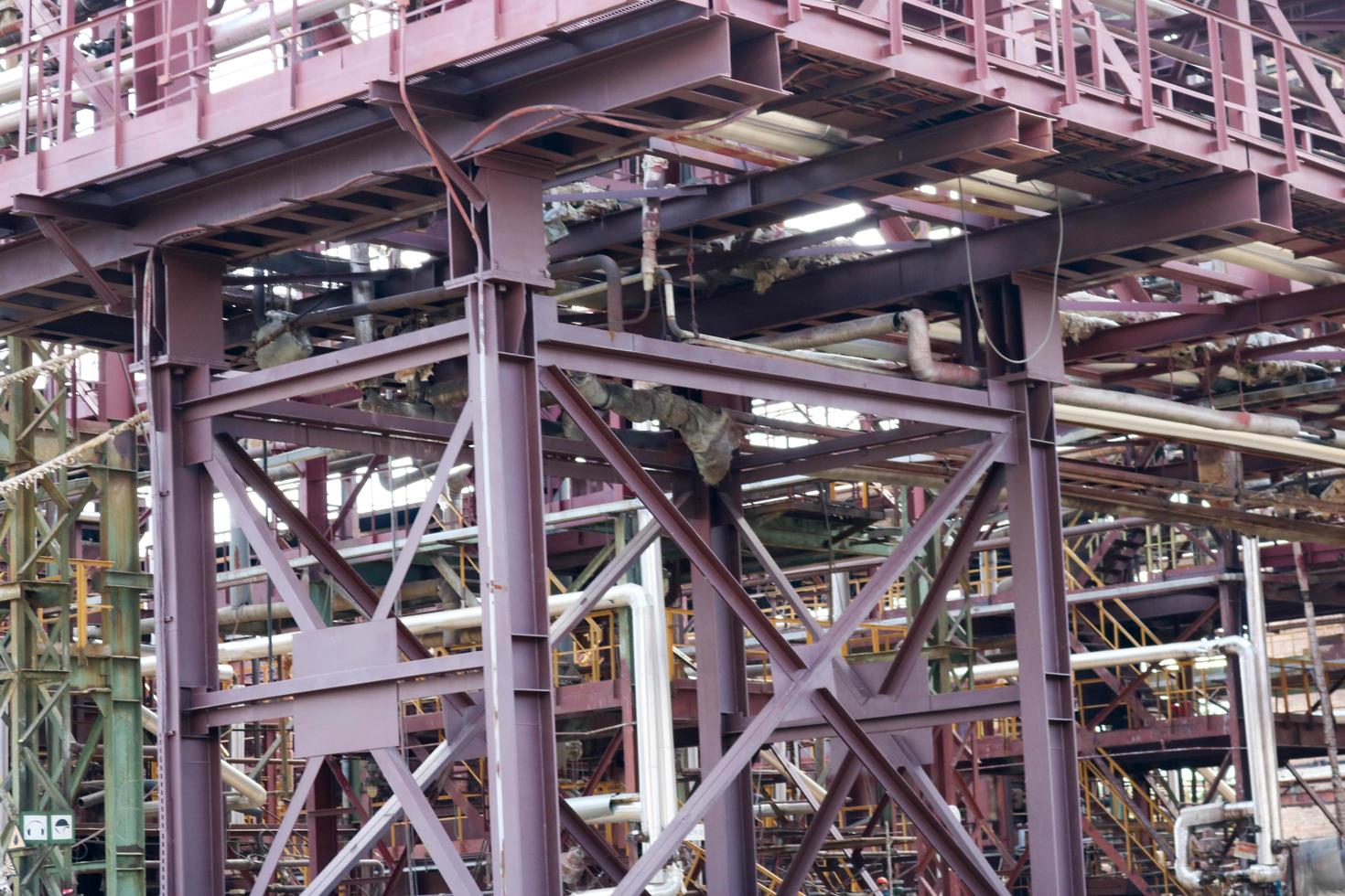 um grande cavalete de tubulação de metal de ferro com tubos e fios elétricos e equipamentos na refinaria petroquímica refinaria industrial foto