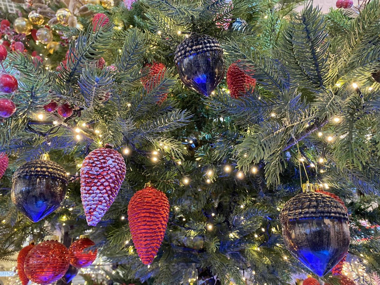 brinquedos de natal, bolas de cor rosa, uma guirlanda brilhante pendurada no galho da árvore de natal. fechar-se foto