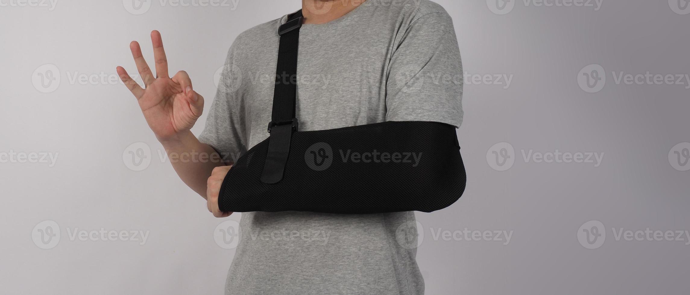 braço quebrado. suporte de terapia de estilingue de braço e coberto ao redor do braço quebrado da primeira articulação do cotovelo. foto