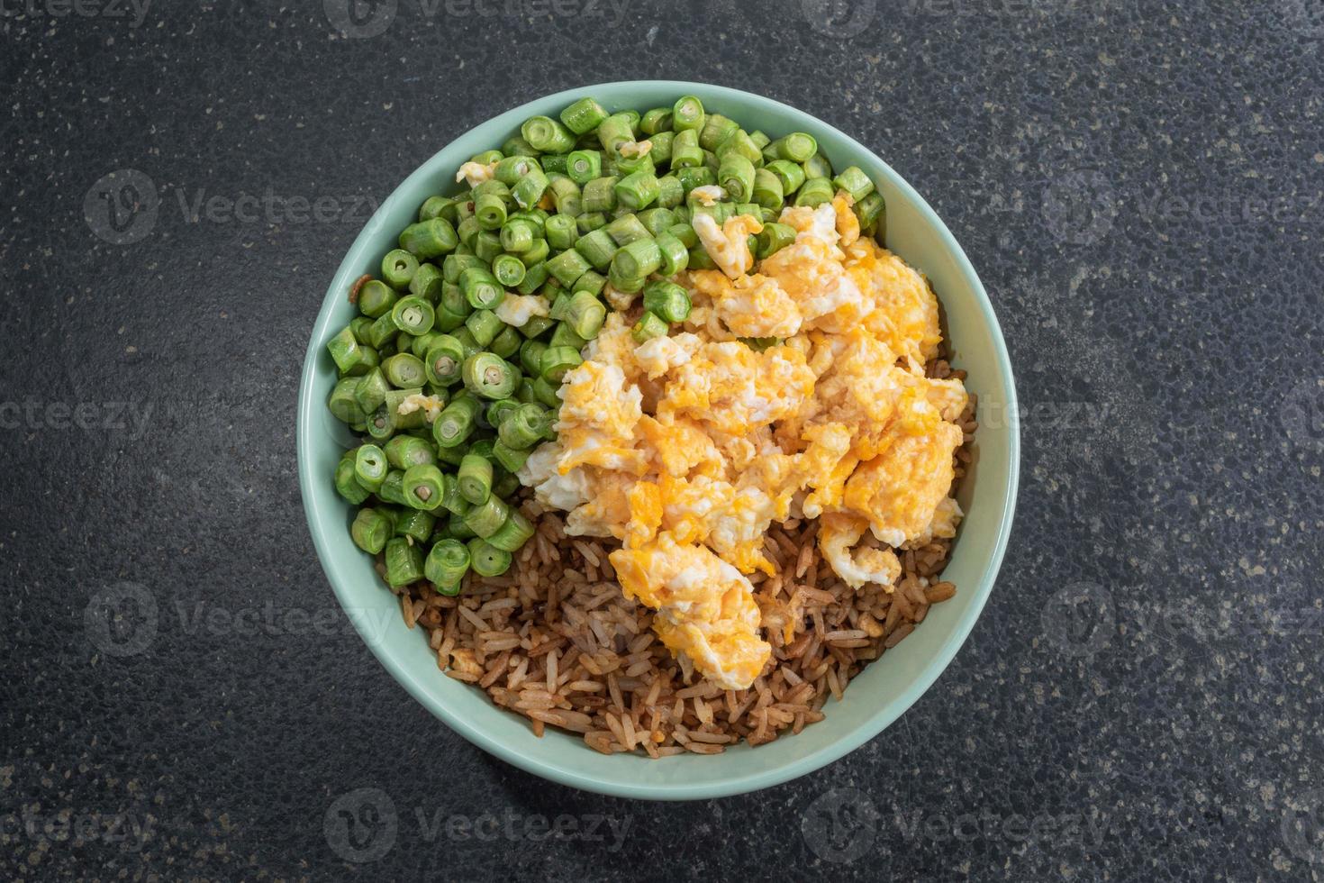 arroz frito com ovo e feijão em tigela verde na mesa de ardósia. foto