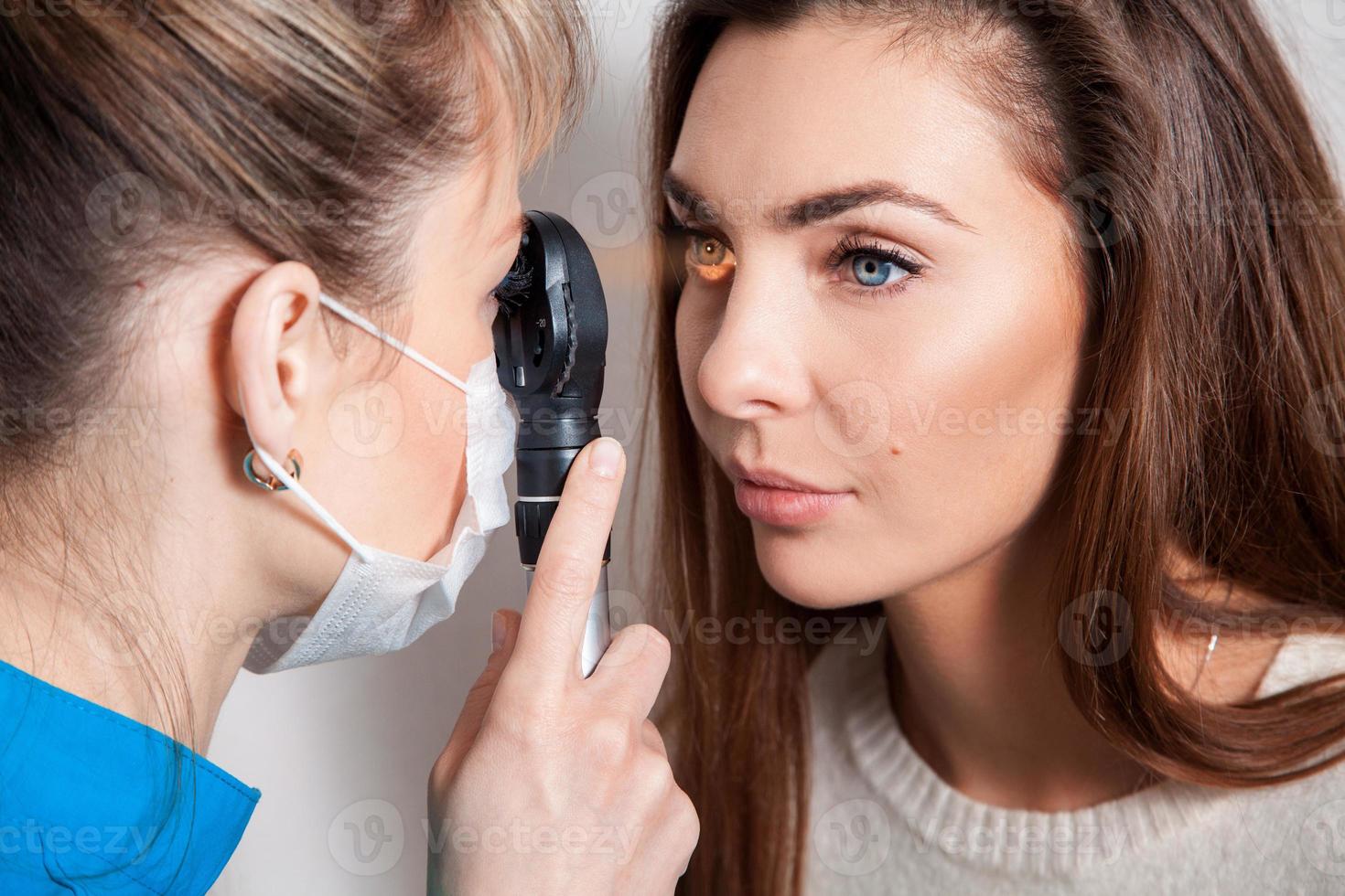 oftalmologista examina os olhos usando um dispositivo oftalmológico foto