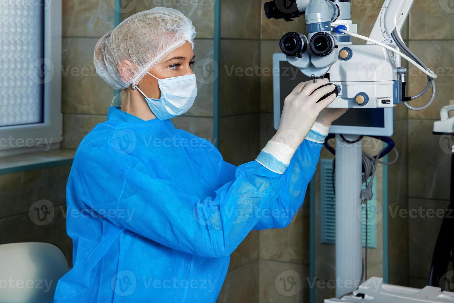 médico verifica o microscópio operacional antes da cirurgia foto