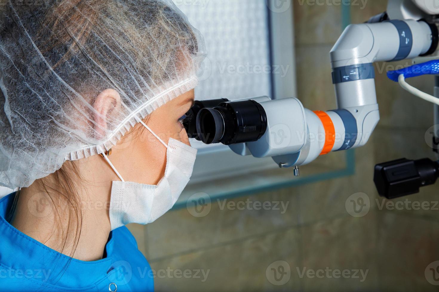 fechar o retrato do médico com microscópio de operação foto