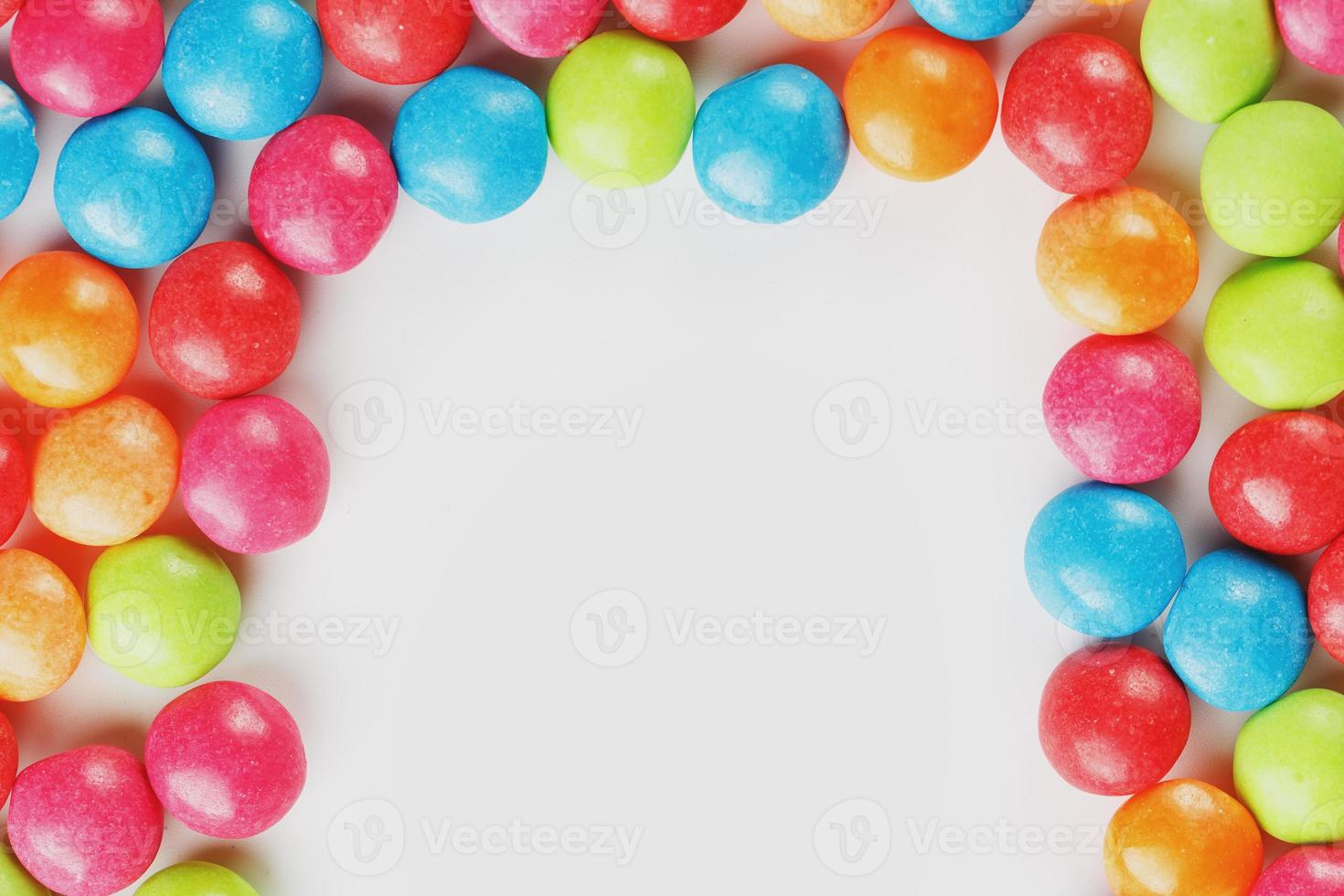 quadro de doces multicoloridos close-up. esmalte multicolorido drageia colorida arco-íris em um fundo branco foto